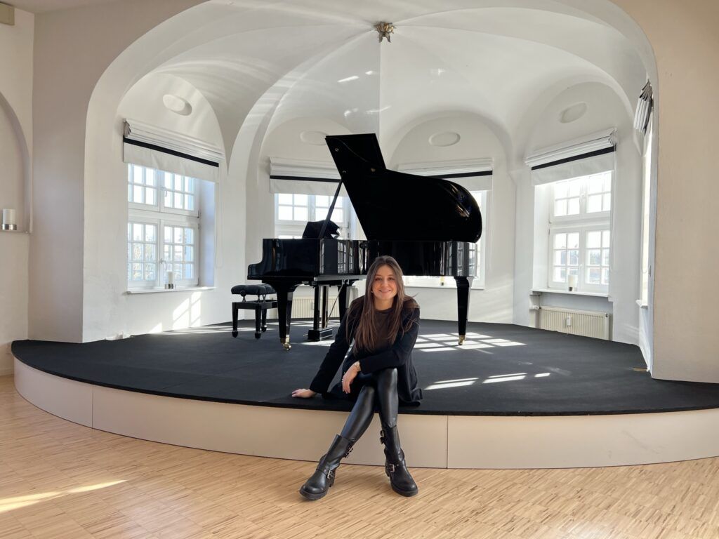 Chiara Abenteuer sitzt im Blauen Saal auf der Bühne vor dem Flügel